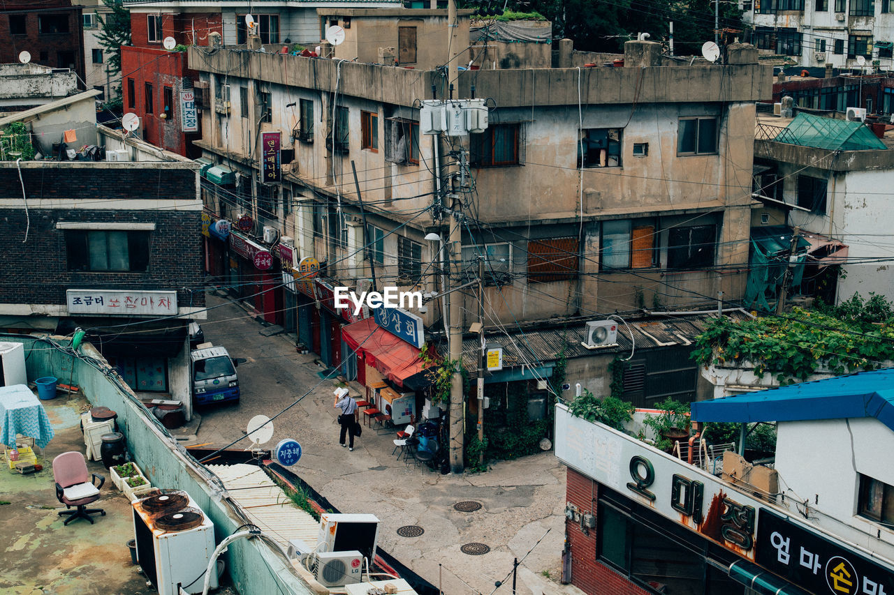 HIGH ANGLE VIEW OF STREET AMIDST BUILDINGS