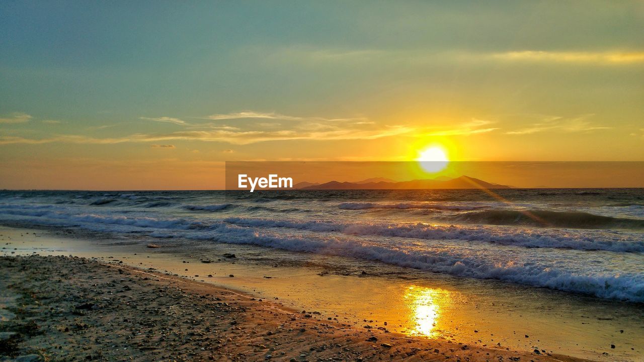 Scenic view of beach against sky during sunset