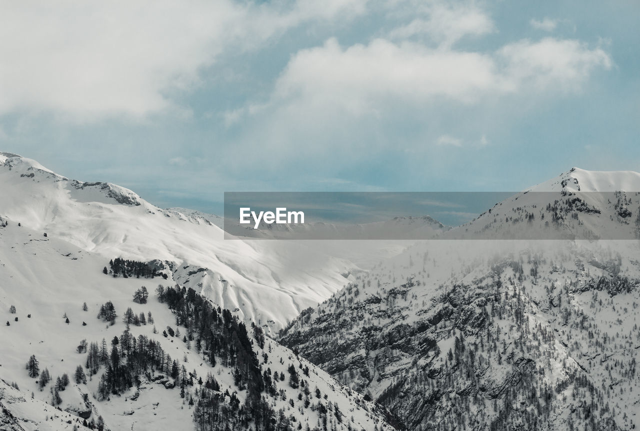 Scenic view of snow covered mountains against sky