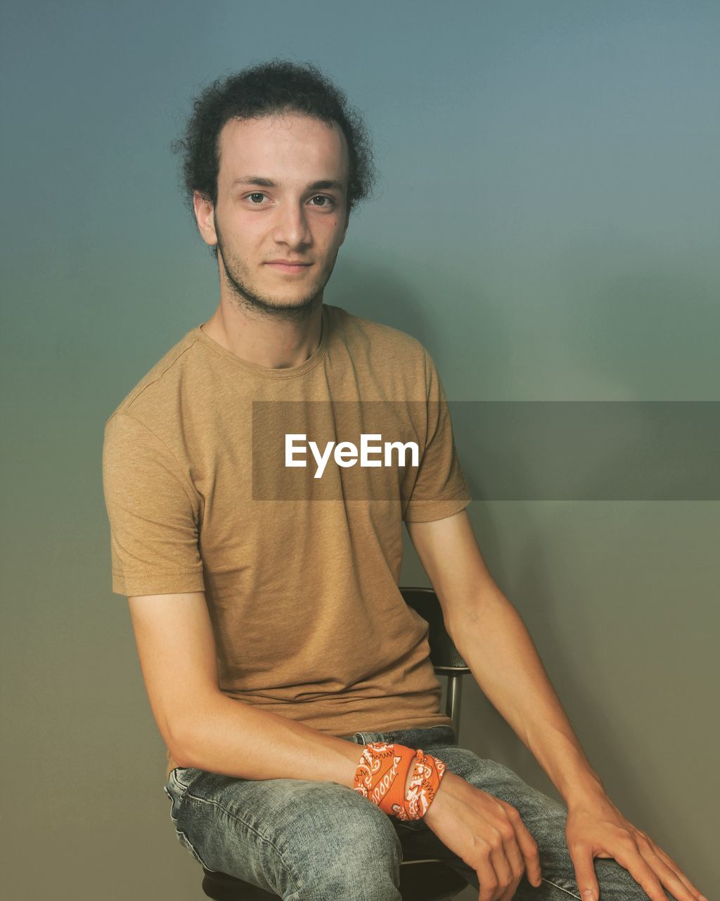 Portrait of young man standing against wall