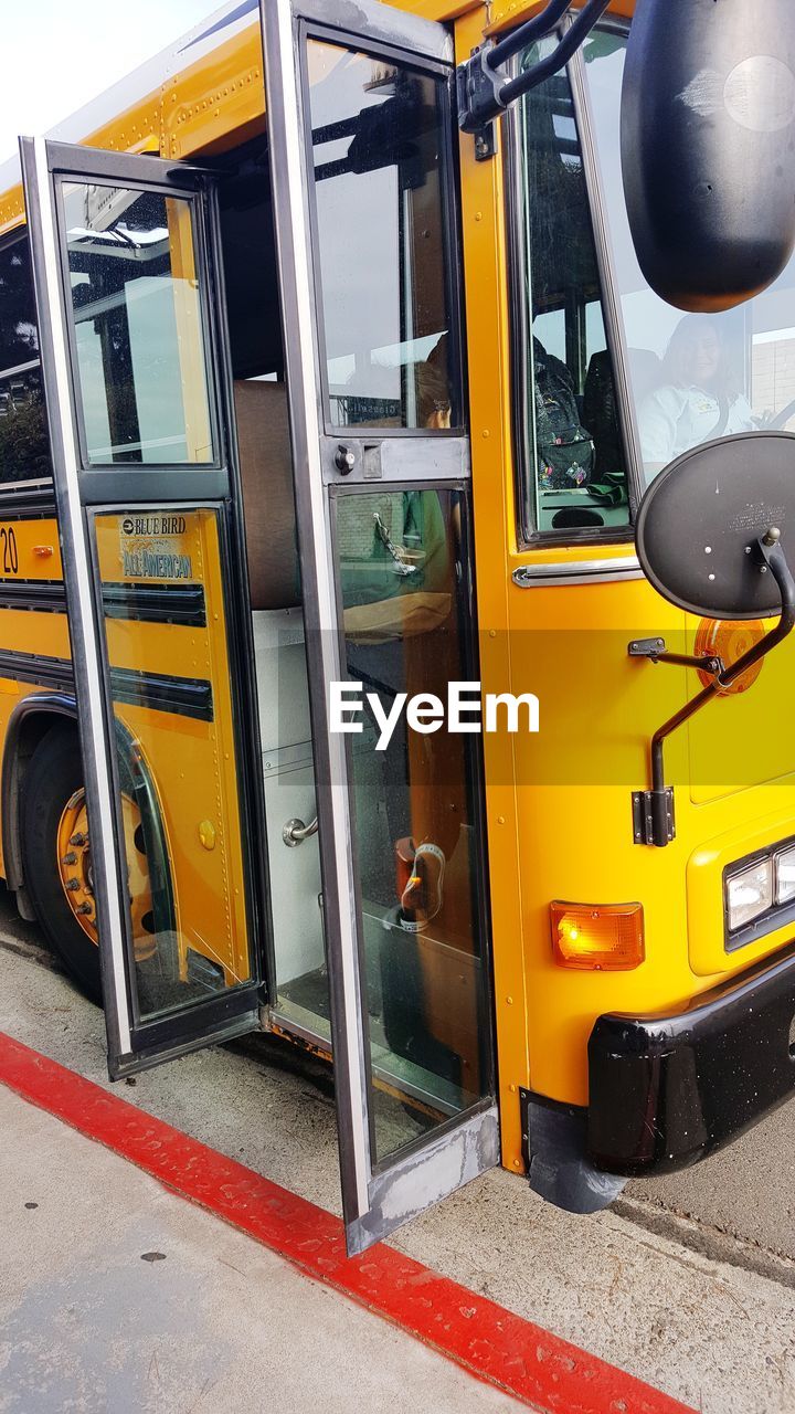 Open doors in yellow bus on street