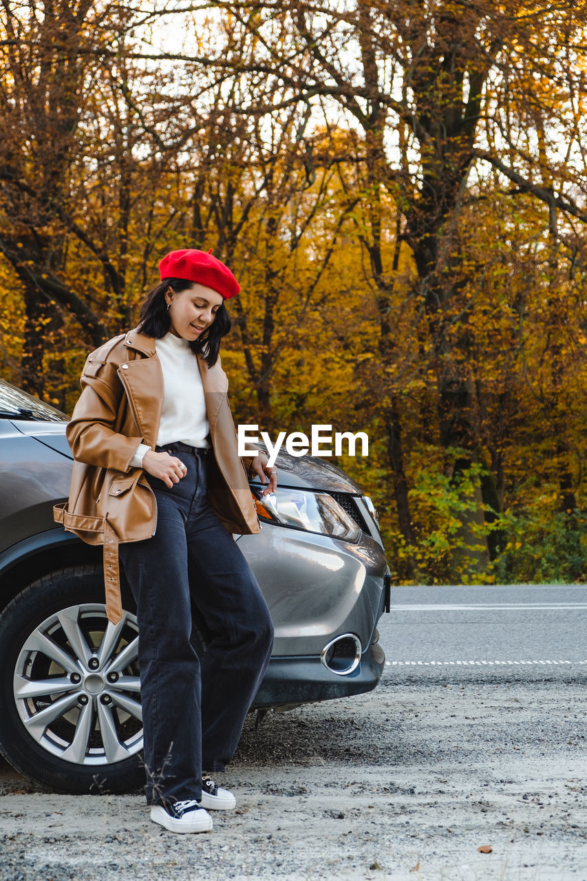 side view of woman standing by car