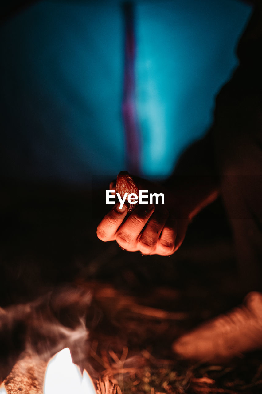 CLOSE-UP OF HUMAN HAND HOLDING A BURNING