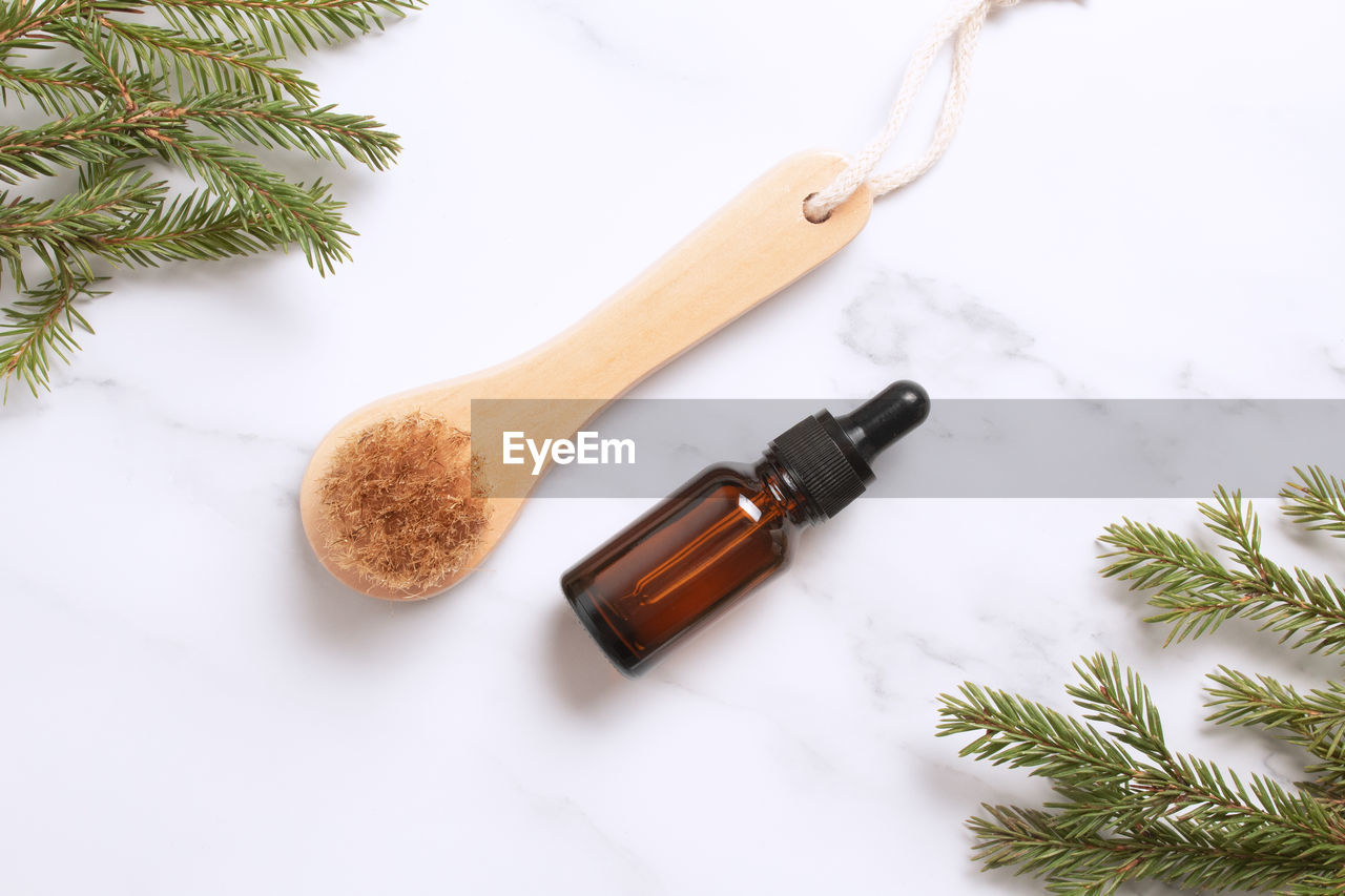 Brown glass bottle with serum, essential oil or other cosmetic product, dry massage brush.