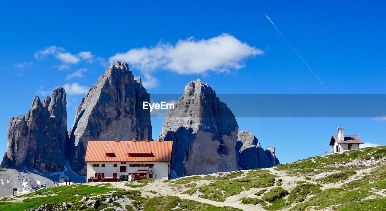 PANORAMIC VIEW OF BUILDINGS AND MOUNTAINS AGAINST SKY