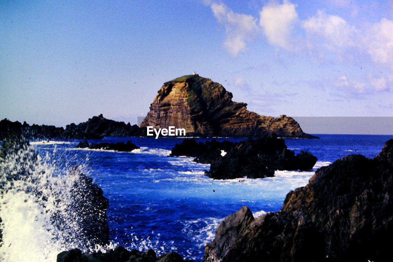 SCENIC VIEW OF SEA WITH ROCKS IN BACKGROUND