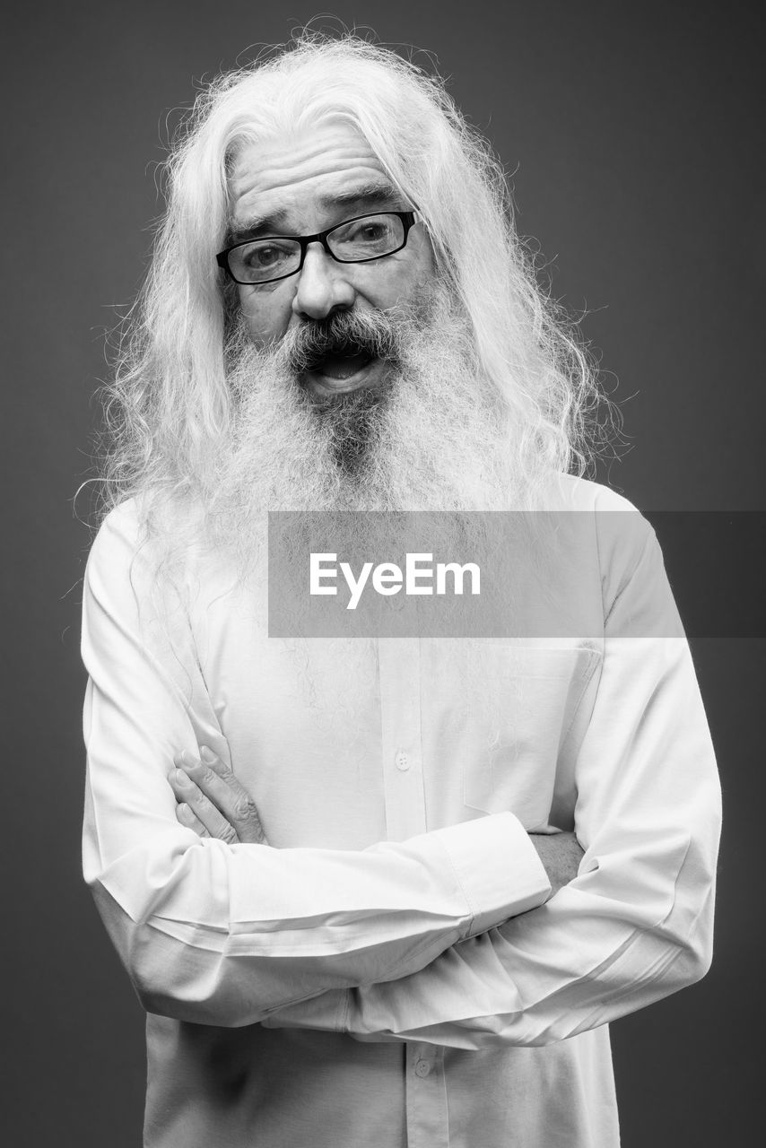 Portrait of man standing against black background