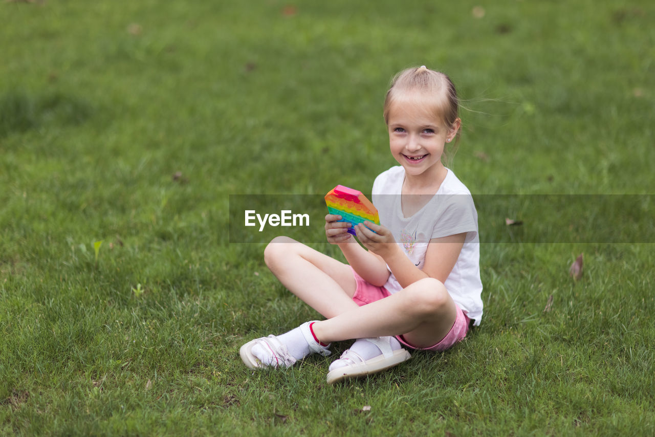 Portrait of cute girl sitting on field