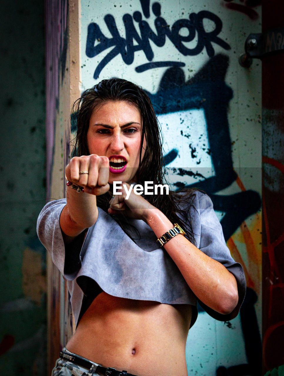 PORTRAIT OF BEAUTIFUL WOMAN STANDING ON GRAFFITI