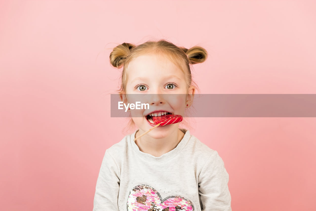 portrait of cute girl with eyes closed standing against yellow background