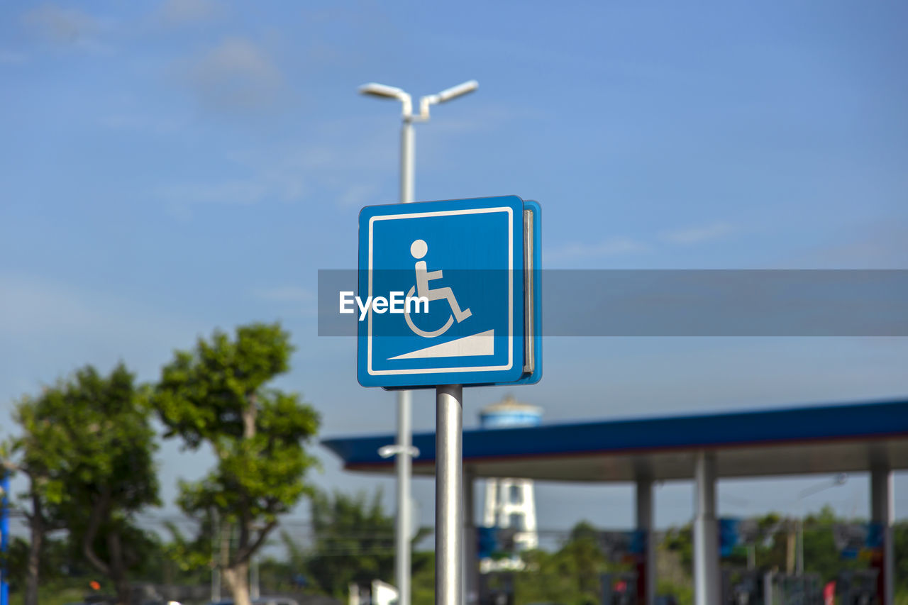 LOW ANGLE VIEW OF SIGN AGAINST BLUE SKY