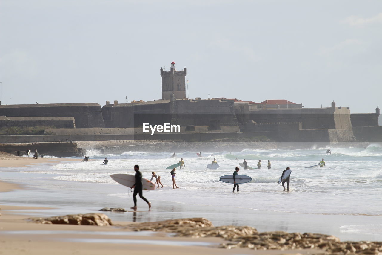 group of people on beach against clear sky