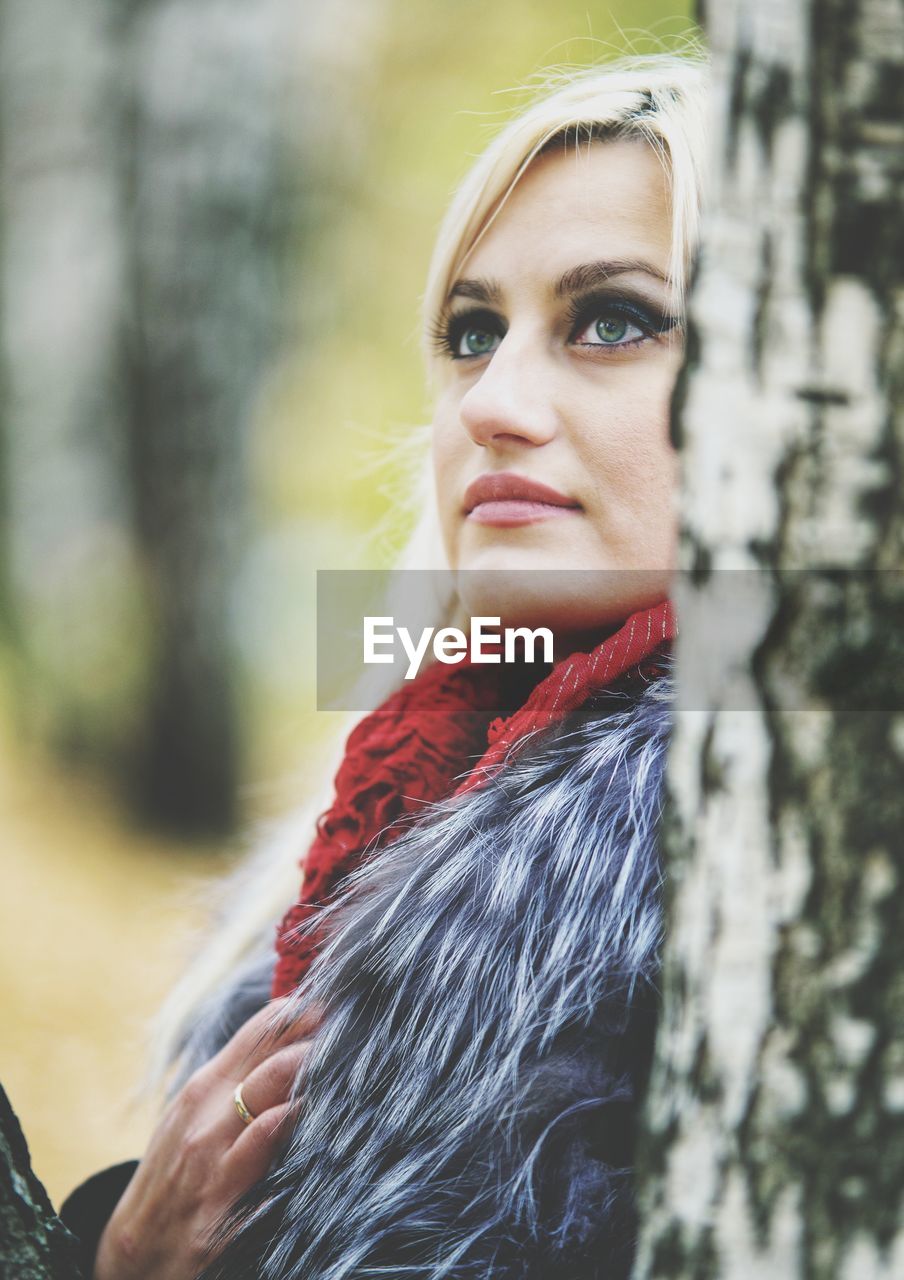 PORTRAIT OF YOUNG WOMAN LOOKING AWAY OUTDOORS