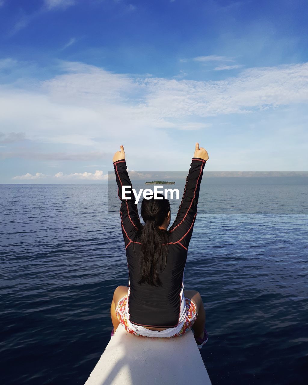 Rear view of woman by sea against sky