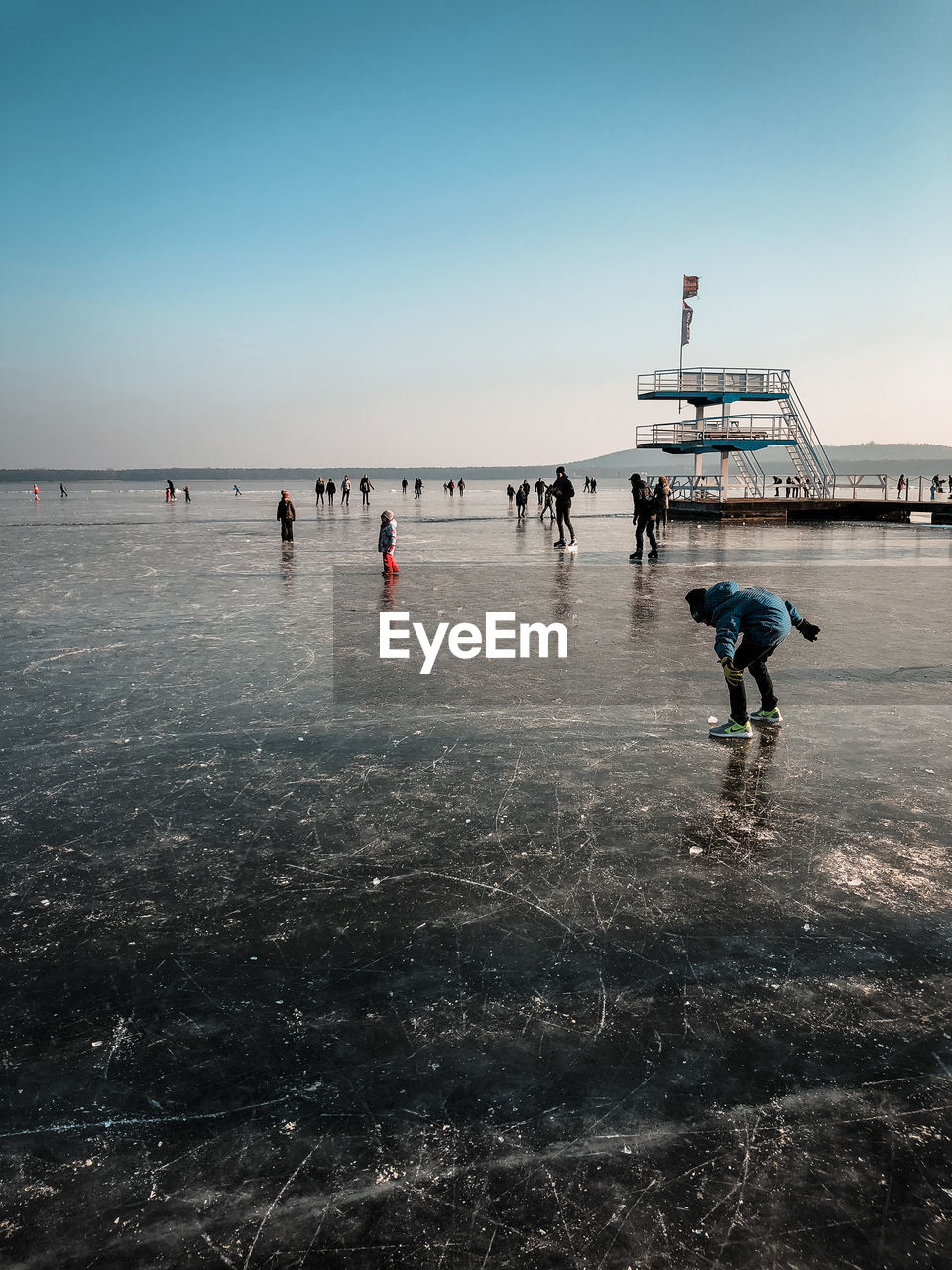 PEOPLE PLAYING ON SNOW AGAINST CLEAR SKY