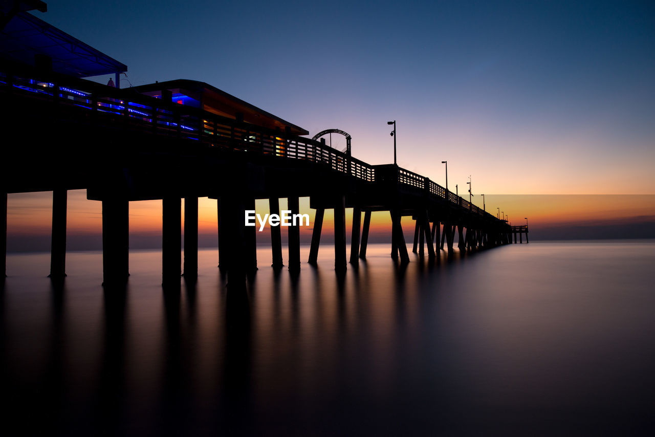 Pier in calm water at dusk