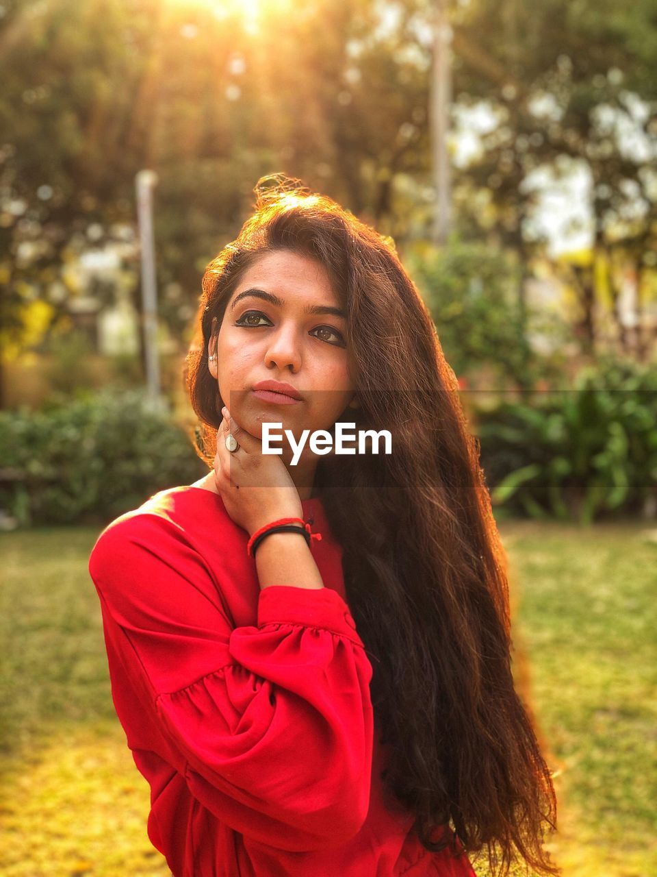 PORTRAIT OF BEAUTIFUL YOUNG WOMAN AGAINST PLANTS