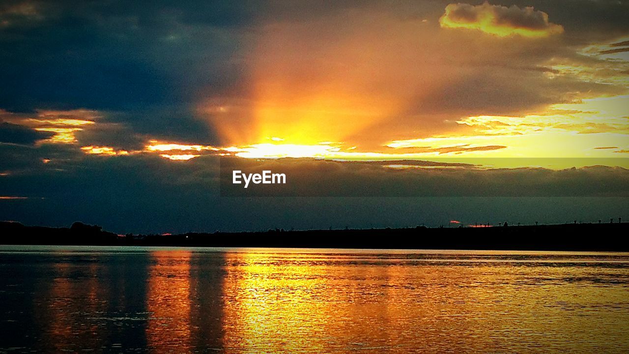 SCENIC VIEW OF SUNSET OVER LAKE AGAINST SKY