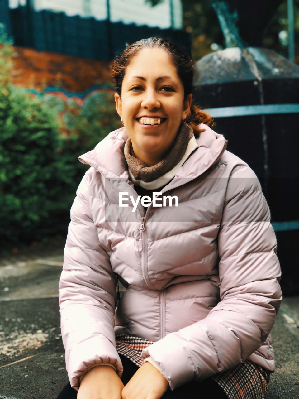 Portrait of smiling young woman sitting outdoors