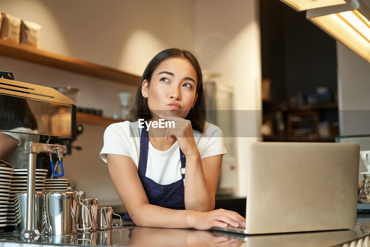 portrait of young woman using laptop at table