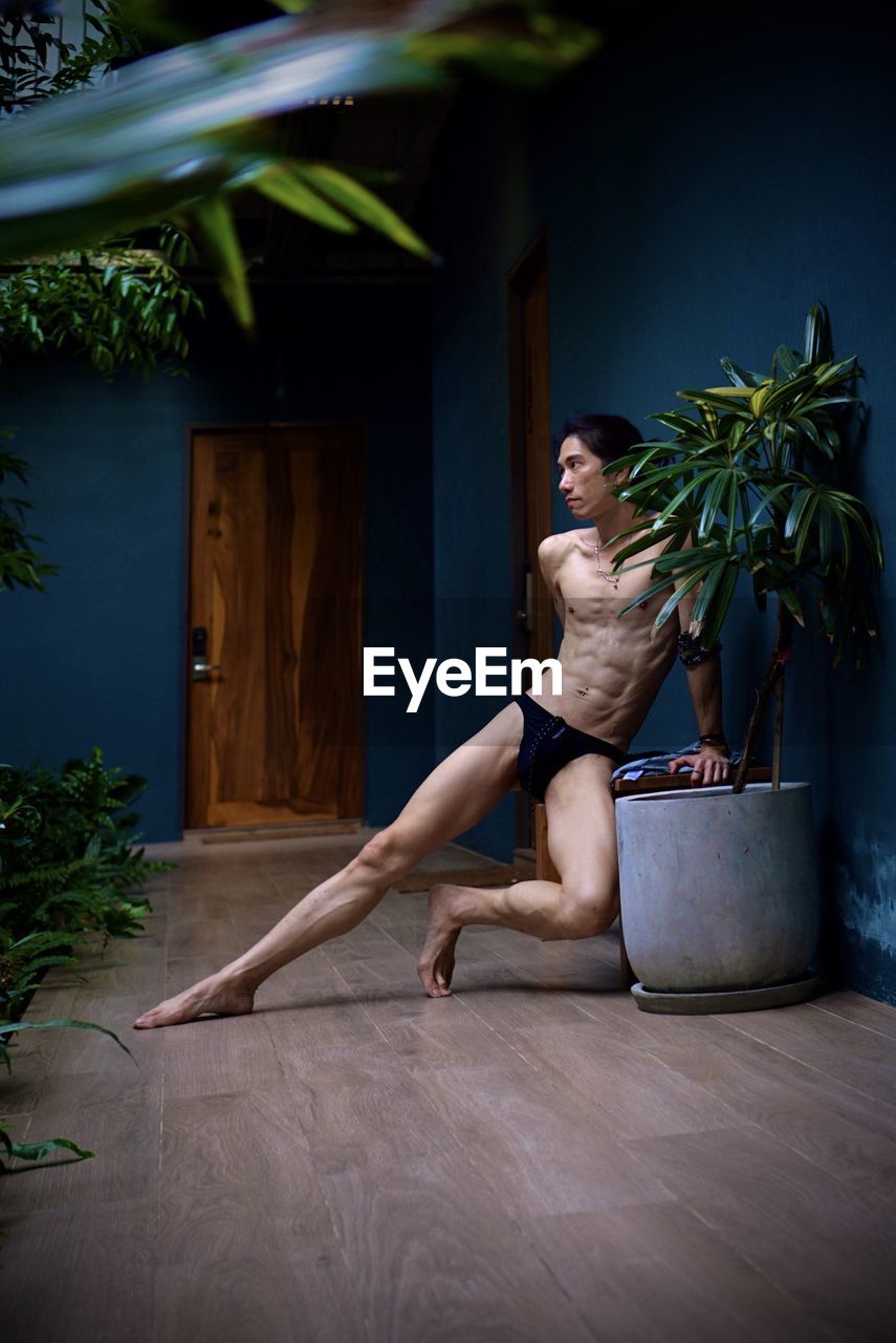 Portrait of a man sitting on hardwood floor