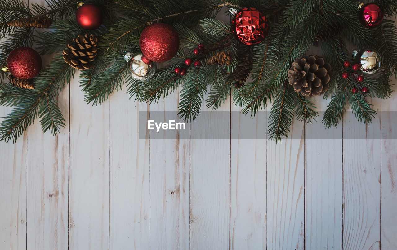 Christmas greenery and decorations against rustic white wood backdrop.