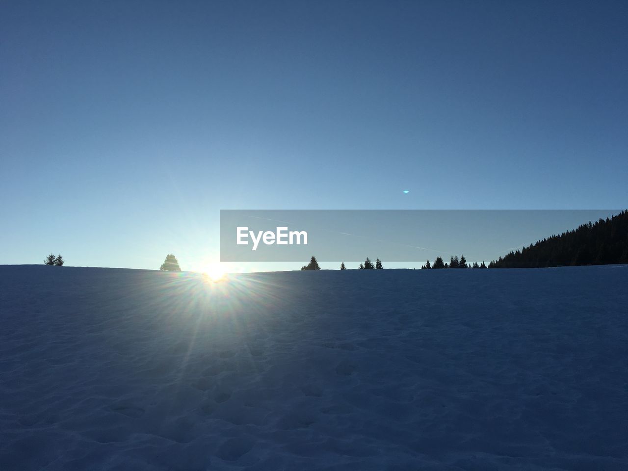 SILHOUETTE PERSON ON SNOWCAPPED LANDSCAPE AGAINST CLEAR SKY