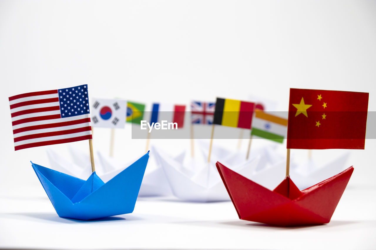 Close-up of flags on paper boats against gray background