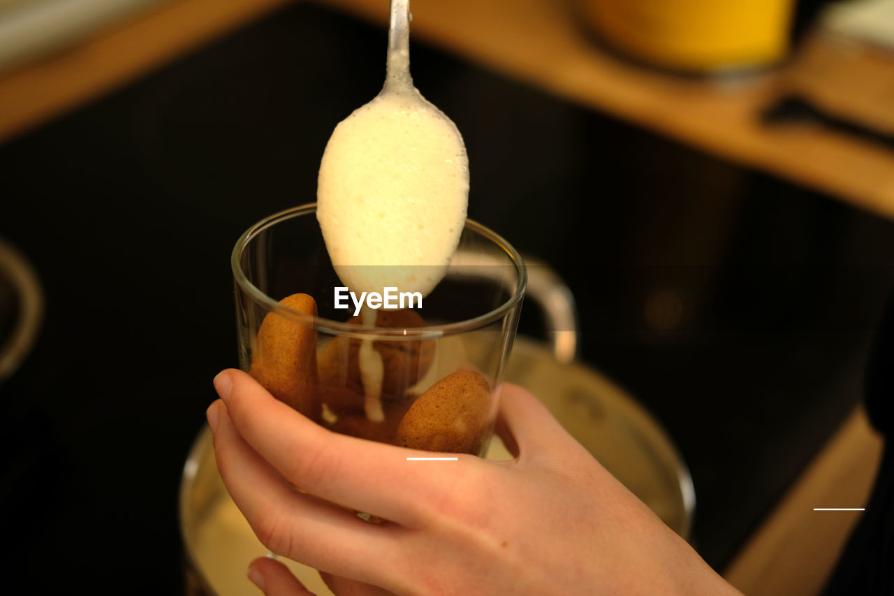 CLOSE-UP OF HAND POURING TEA IN CUP