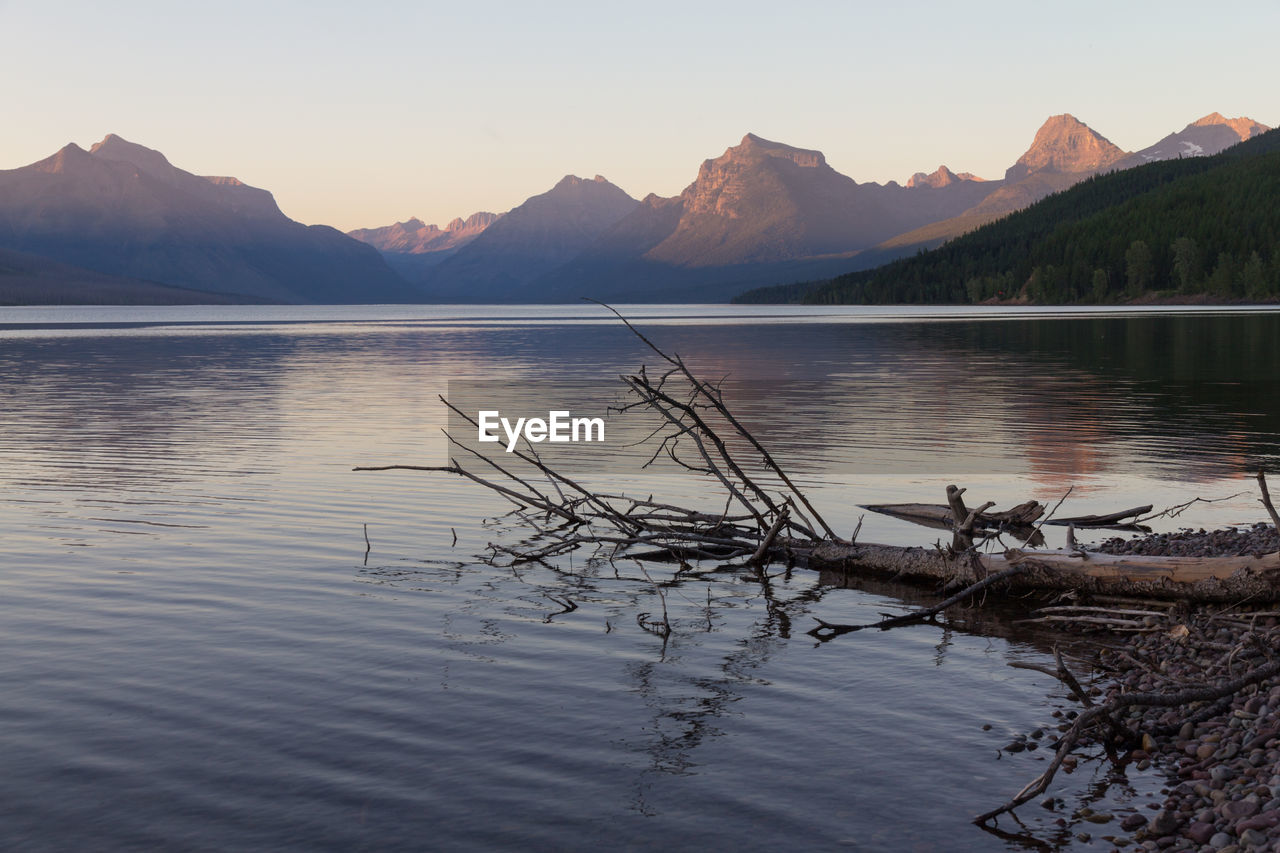 Scenic view of lake by mountains against sky