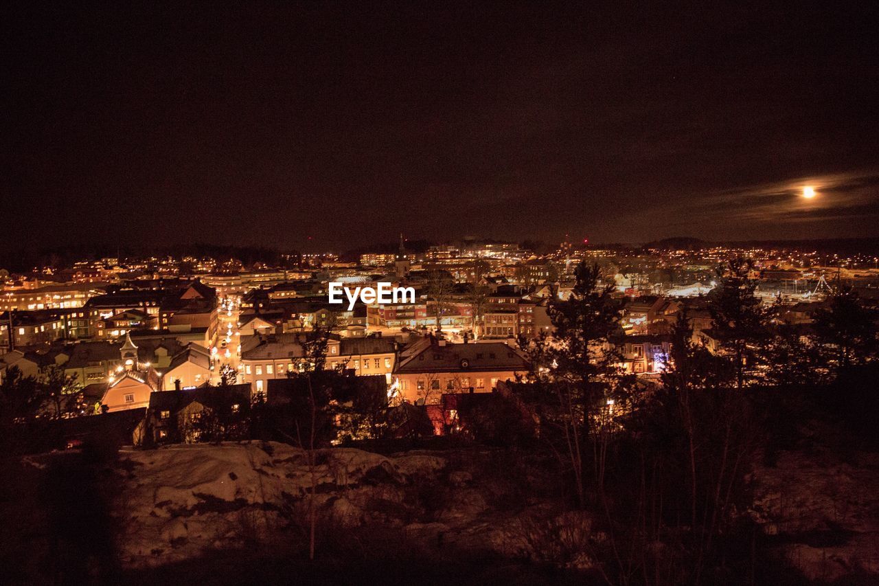 Illuminated cityscape against sky at night