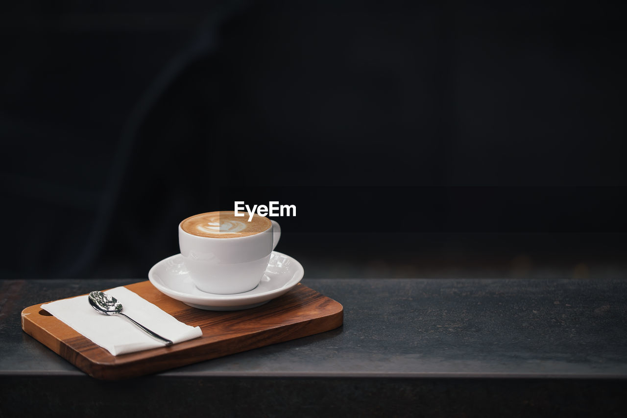 Cup of coffee on wooden table, vintage color