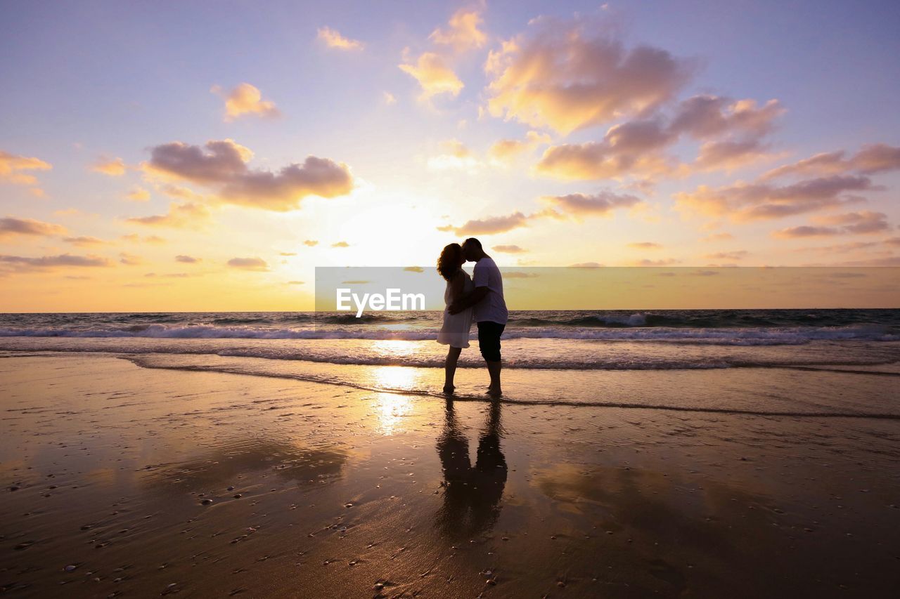 SILHOUETTE OF PEOPLE STANDING ON BEACH