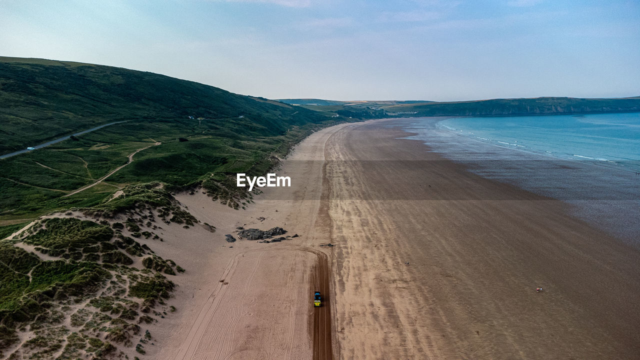 land, water, sea, beach, sky, coast, nature, environment, scenics - nature, landscape, beauty in nature, sand, ocean, travel, travel destinations, body of water, shore, coastline, transportation, cloud, horizon, holiday, tranquility, trip, vacation, tourism, outdoors, motion, day, no people, tranquil scene, blue, non-urban scene, sports, summer, wave, terrain