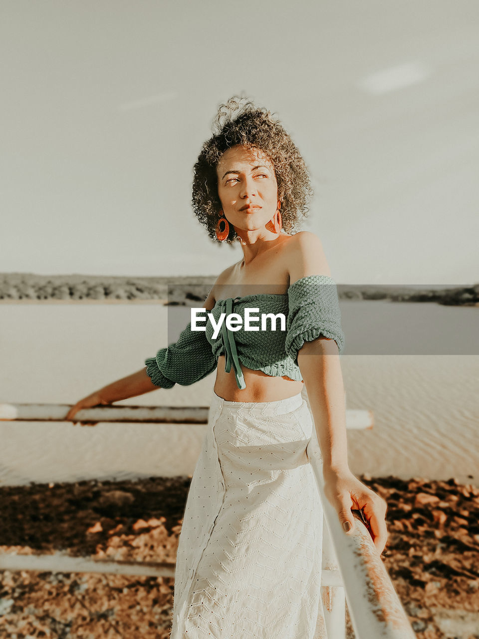 Woman standing at beach against sky