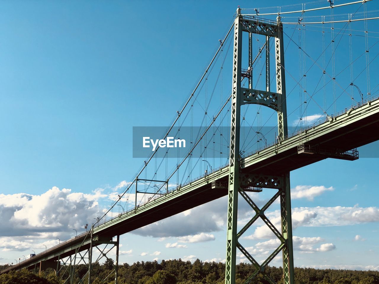 Low angle view of suspension bridge against sky