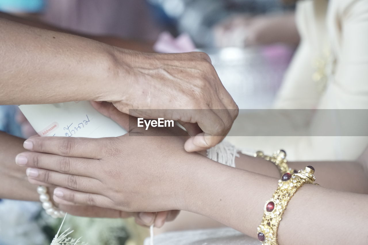 MIDSECTION OF COUPLE HOLDING HANDS WITH ARMS