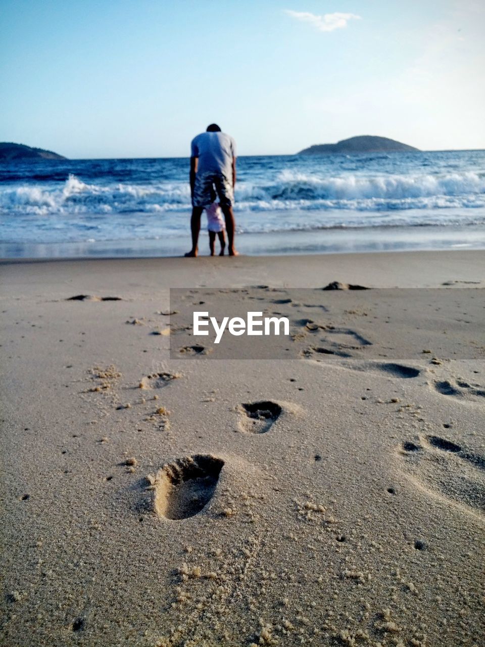 Rear view of man with child on beach