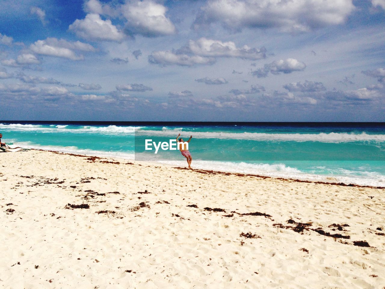 WOMAN ON BEACH AGAINST SKY