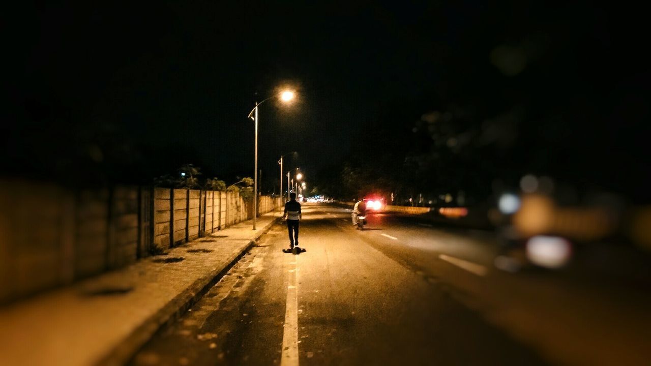 WOMAN WALKING ON ROAD AT NIGHT
