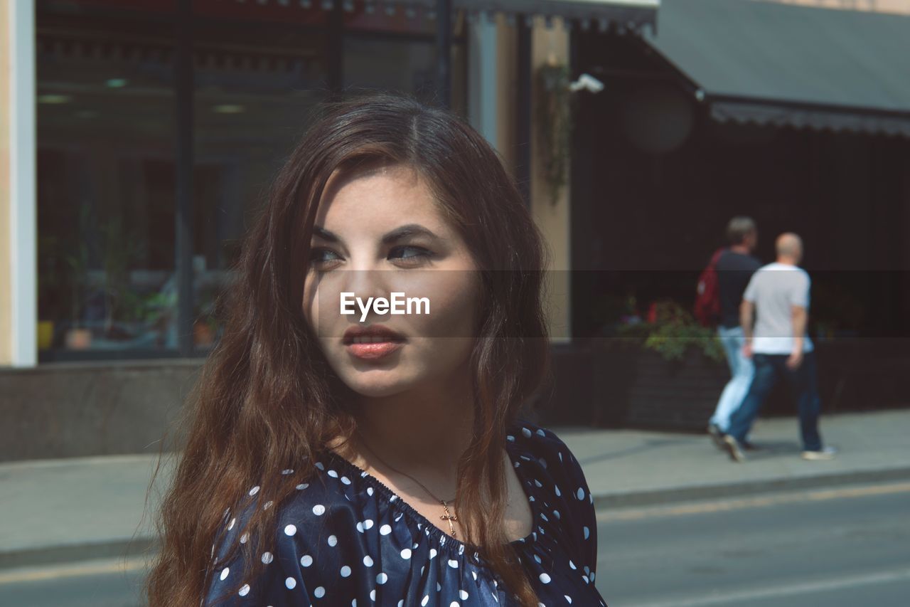 Thoughtful young woman in city