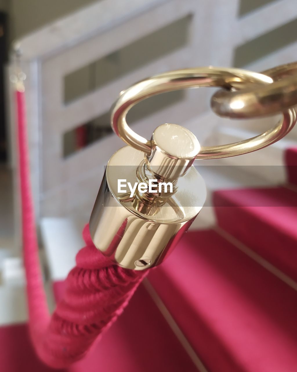 CLOSE-UP OF HAND HOLDING RED WINE WITH METAL