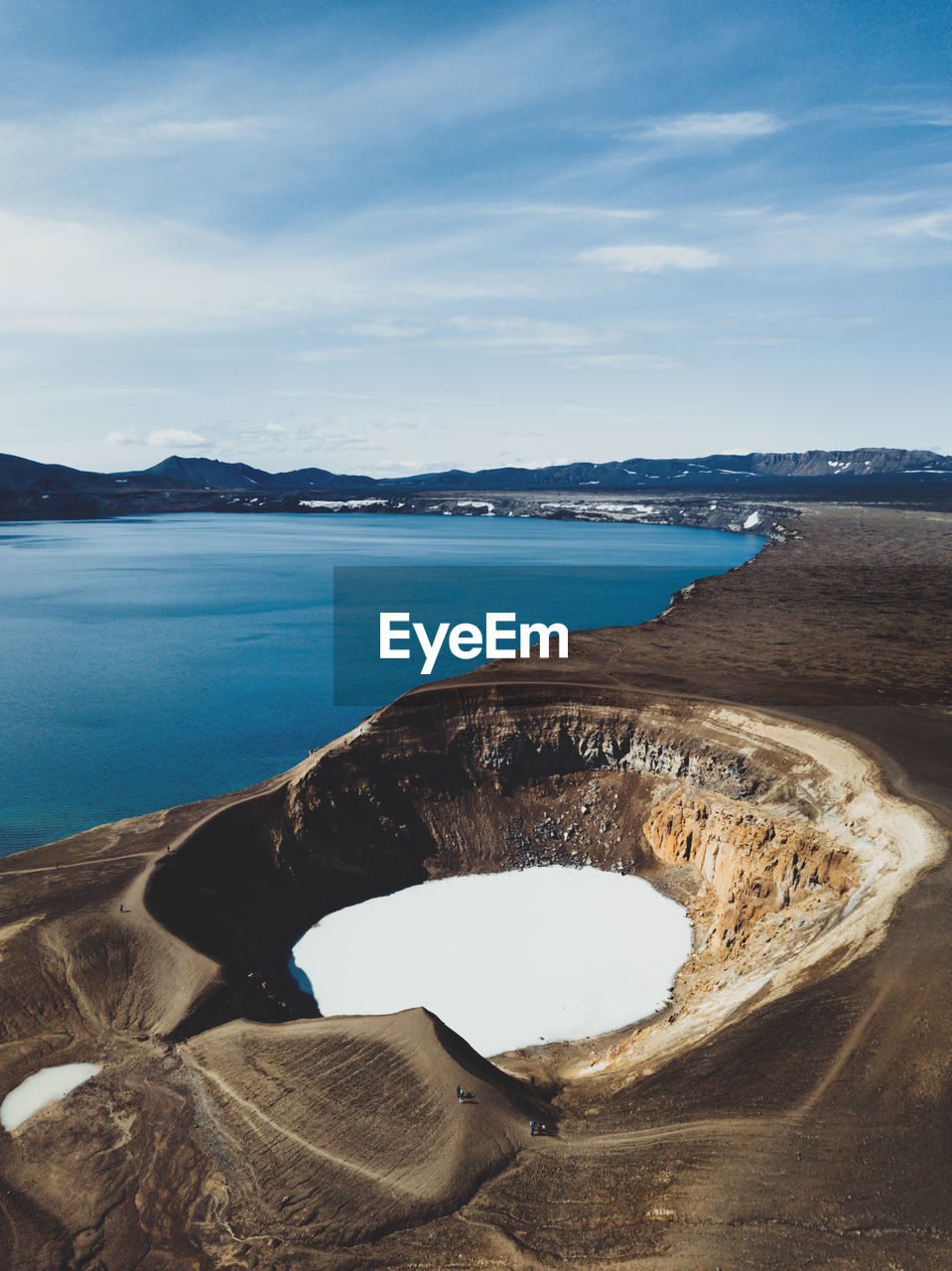 High angle view of volcanic crater by sea