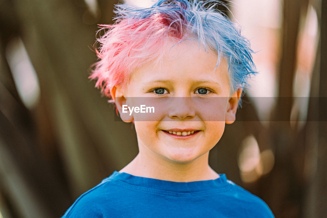 Young boy with colored hair smiling at camera