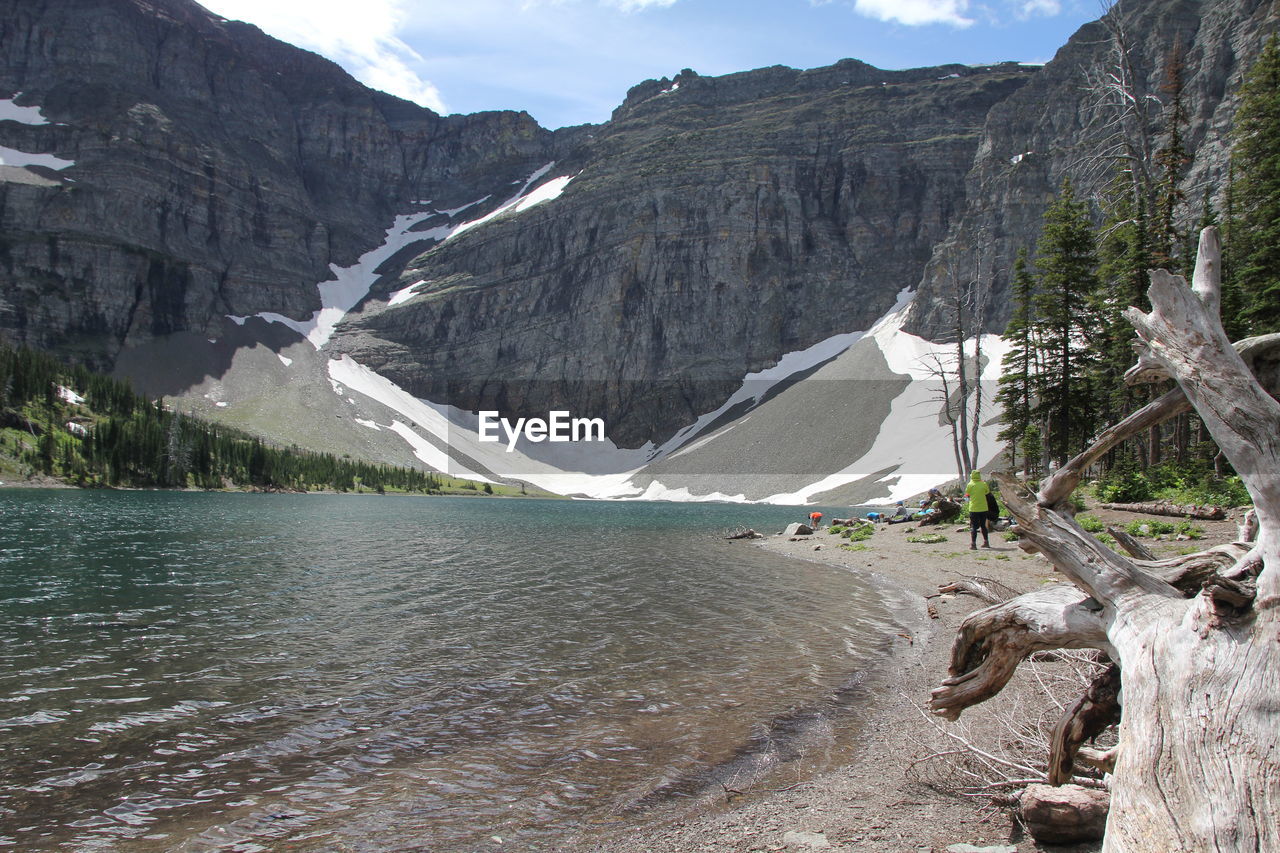 Scenic view of rocky mountains by lake during winter