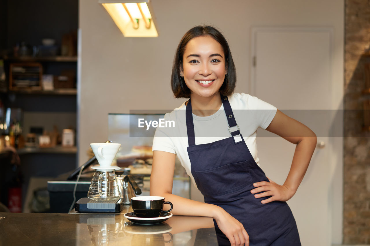 portrait of young woman sitting on table in cafe