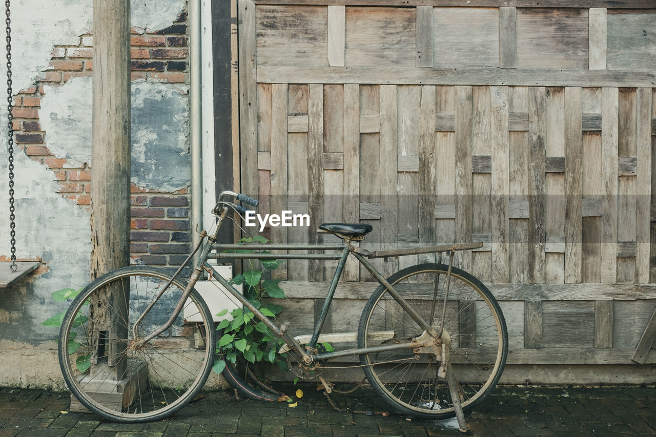 Bicycle parked against old building