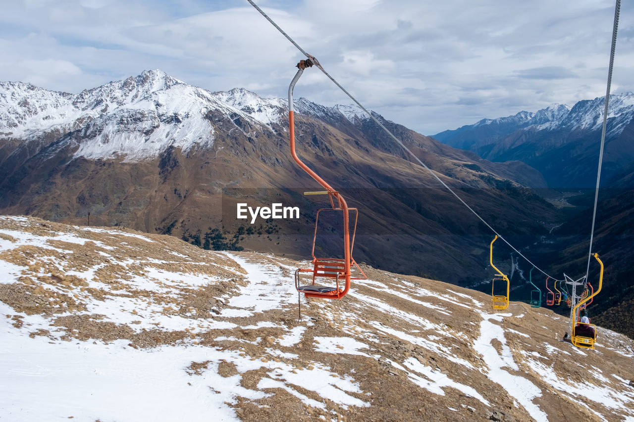 Mountain landscape with chairs of a single-seat cable car for lifting tourists, skiers and climbers