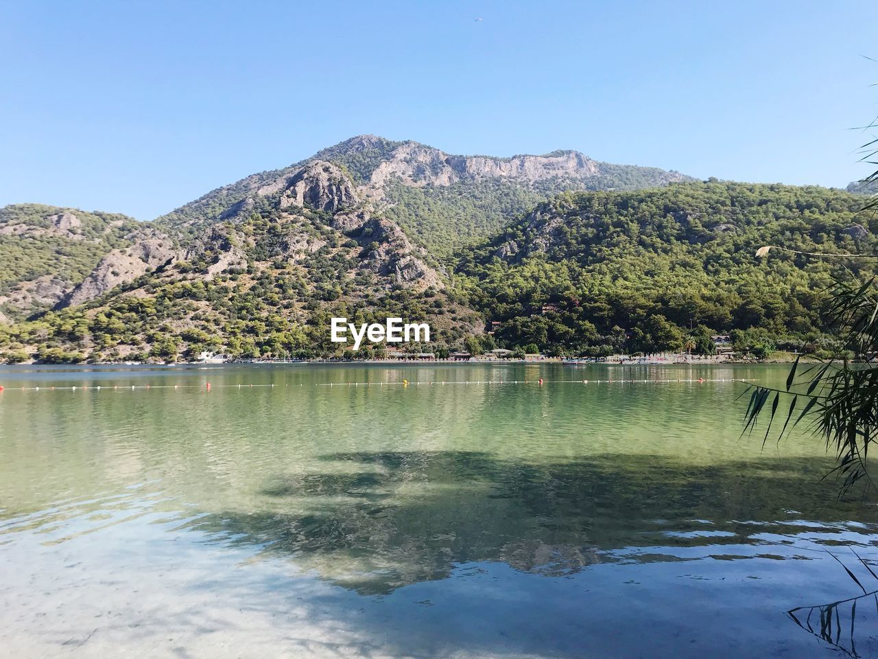 Scenic view of lake and mountains against clear sky