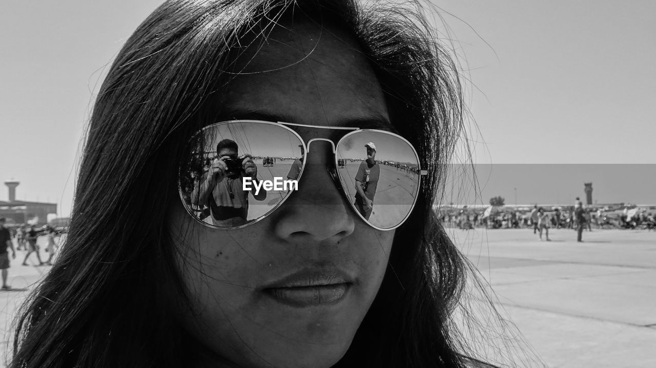 CLOSE-UP OF YOUNG WOMAN WEARING SUNGLASSES